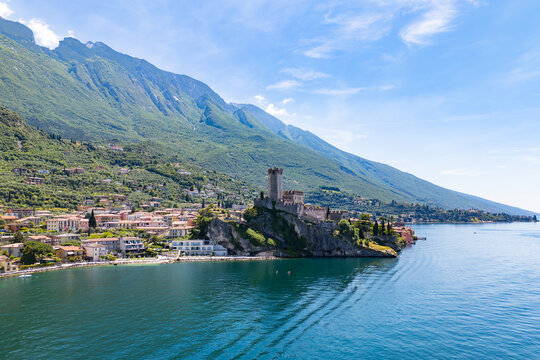 Aerial panorama of Malcesine Castle above Lake Garda with mountain backdrop. Northern Italy travel scenery