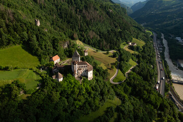 Fototapeta premium Trostburg Castle complex on a Dolomite slope, aerial view. Heritage landmark dominating the surrounding landscape