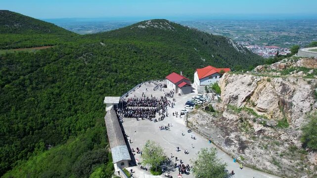 Aerial orbit of the Shna Ndout Church showing the dramatic mountain cliff side location
