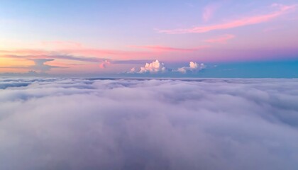 Fototapeta premium Aerial view of a sea of clouds bathed in the soft hues of a pastel sunrise sky