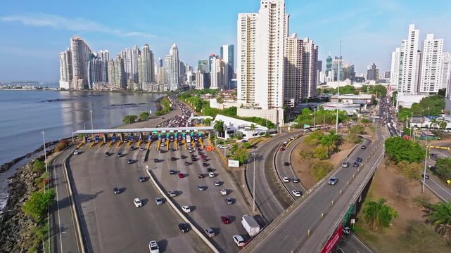 Aerial drone shot over the southern corridor, the camera is moving towards the toll booth and Panama City in the background
