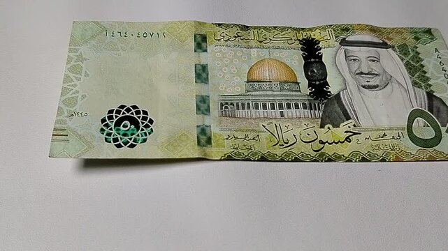 Fifty riyals currency notes illustrating banking, financial management, international trade, and money transaction concepts in the global economy.