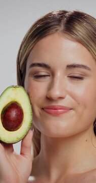 Skincare, face and woman in studio with avocado for natural, organic or hydration routine. Cosmetic, glow and portrait of female person with fruit for facial dermatology treatment by white background