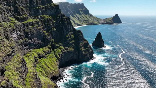 Cinematic aerial drone footage of massive volcanic cliffs at Ponta do Sol, Santo Ant&atilde;o, featuring a rugged coastline meeting the deep blue Atlantic Ocean in the scenic Cape Verde islands.