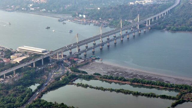 Wide aerial of the entire Atal Setu bridge cutting across a serene Mandovi River, with structured cables, moving traffic, and scenic surroundings creating a balance of engineering and nature.