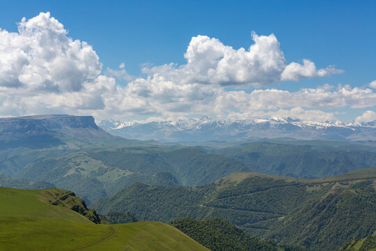 Panoramic view of Main Caucasus range and green mountain slopes at summer travel