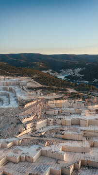 Aerial view of Jadrankamen white stone quarry with terraced excavations overlooking the coastal town and bay in Pucisca, Splitsko-dalmatinska, Croatia.