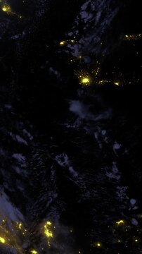 A stunning view of Earth at night showcases glowing city lights scattered across the landscape. The contrast of dark water and shimmering lights creates a breathtaking scene from space.