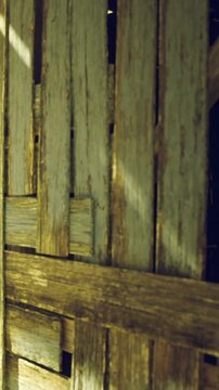 Sunlight filters through rustic wooden planks, casting warm shadows in a cozy corner. The aged texture adds character and charm to the serene atmosphere of the space.