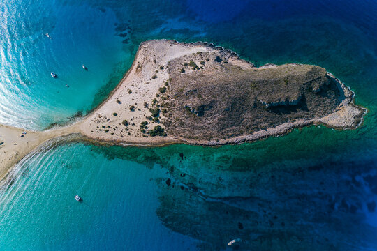 Aerial drone photograph of a the iconic rocky island peninsula of Simos beach, a Bay on the Greek island of Elafonisi (or Elafonissos) often translated as "Deer Island"