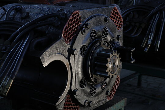 Heavy industrial traction motor with gear in a workshop.