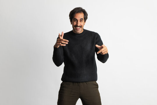 Happy man poses playfully in a cozy black sweater for a stylish shoot