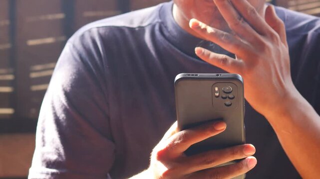 Close up of man smoking cigarette while using smartphone, typing messages or browsing social media. Bad habit, addiction and unhealthy lifestyle.