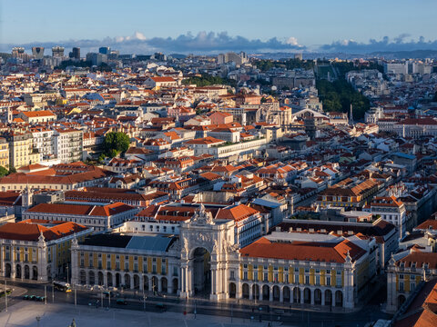 Aerial view of the Rua Augusta Arch and Praca do Comercio surrounded by historic red-tiled rooftops and the urban skyline of Lisbon, Lisbon, Portugal.