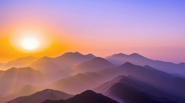 Golden sun rising over successive mountain ranges covered in soft mist creating a scenic view