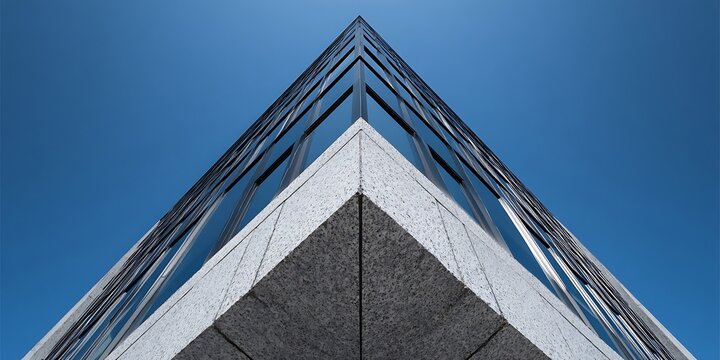 Modern architecture with sharp geometric lines of a building's corner reaching towards a clear blue sky