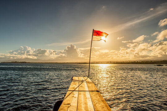 Indonesian flag on a flagpole at the end of a wooden pier, Tumbak Bentenan Marine Park, Southeast Minahasa, North Sulawesi, Indonesia