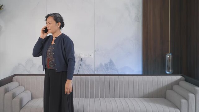 Frustrated senior or old woman having heated conversation argument with someone while talking on mobile phone. She looks very angry, stressed out holding mobile device. Female suffer bad news