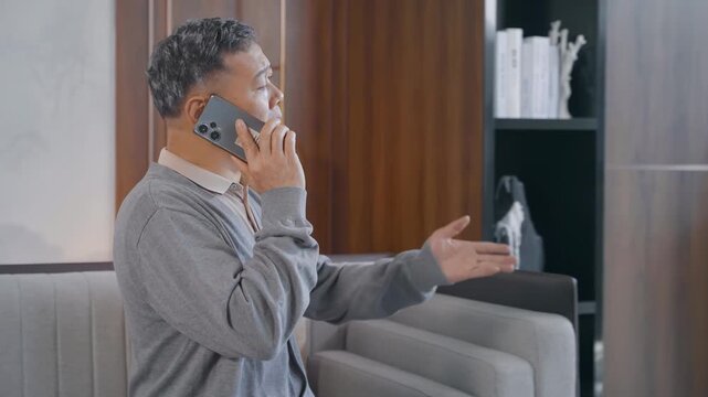 Frustrated senior or old man yells at smartphone, having a heated conversation argument with someone on mobile phone. He looks very angry and stressed, male suffer bad news.