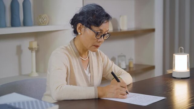 Elderly woman writing letters diary, senior female write something on empty daily planner page to keep from forgetting Alzheimer's concept