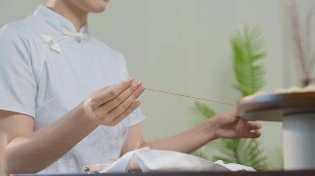 Traditional craftsmanship young creative woman skillfully embroidering colorful design, girl's hand is embroidered in the embroidery frame. Handmade needlework while sitting by workplace