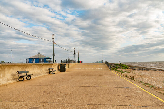 Empty concrete promenade along the coastline of Hunstanton under a dramatic cloudy sky, Norfolk, England.