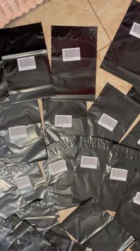 Moscow, Russia, 03.05.2026 Black mailer bags with shipping label for online store. E-commerce seller preparing goods for customer delivery. Small business logistics and product packaging.