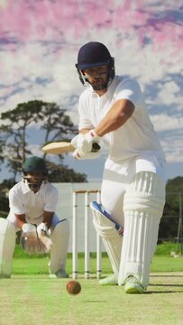 Vertical video: Cricket batsman blocking as bowler bowls ball, keeper collecting to defend stumps