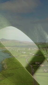 Vertical video: Plane moving wing entering view while cam tracking coast shadow revealing fields