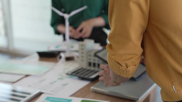 Business professionals are meeting to plan strategies, analyze ESG performance indicators, and develop sustainability strategies incorporating clean energy concepts.