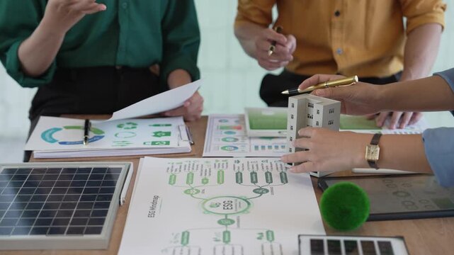 Business professionals are meeting to plan strategies, analyze ESG performance indicators, and develop sustainability strategies incorporating clean energy concepts.