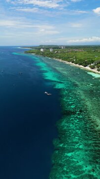 A drone pulls back from a small outrigger boat to reveal Bohol Beach and the reef-lined coast in Panglao, Bohol