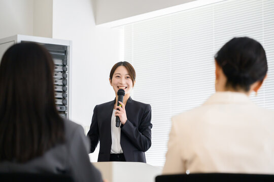 社員の前でプレゼンをする日本人女性