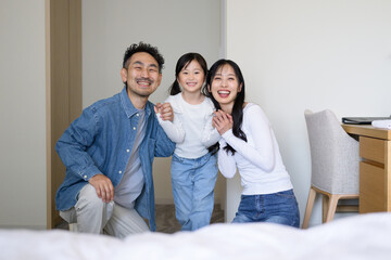 旅行先の客室でカメラ目線の日本人親子 © Yamatatsu