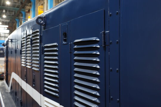 Close up of metal ventilation louvers on a blue locomotive.