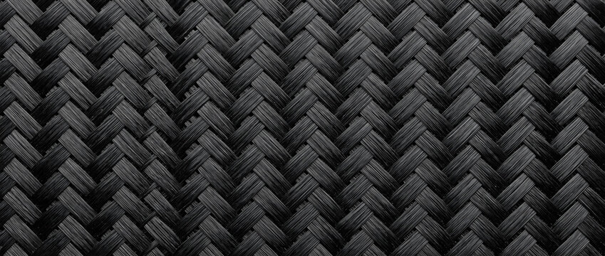 This is a closeup monochrome herringbone woven fabric texture, featuring repeating dark black geometric patterns with subtle shadow contrast for depth.