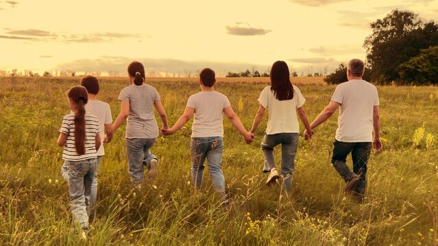 Sunset family adventure, Kids and parents stroll, Hand in hand at dusk, Loving relationships, Strength in unity, Family happiness outdoors, Rural harmony, Walking to the horizon, Evening serenity