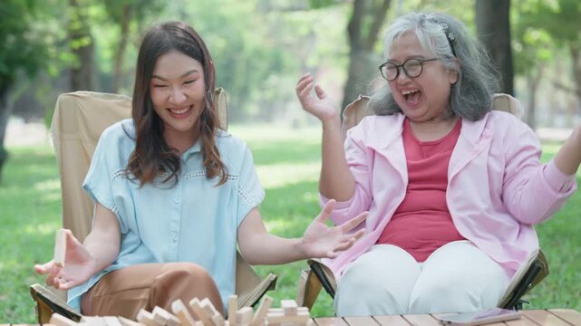 Joyful Moments of Family: In a serene outdoor setting, a multigenerational bond blossoms as a daughter and her mother engage in laughter and fun, their eyes sparkling with pure delight.