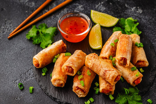 Fried spring rolls served with sauce and lime
