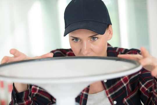 happy woman screwing base on a metal chair