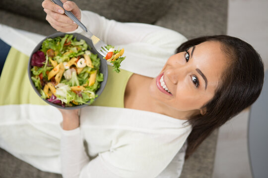 overhead view of a woman eating a salad