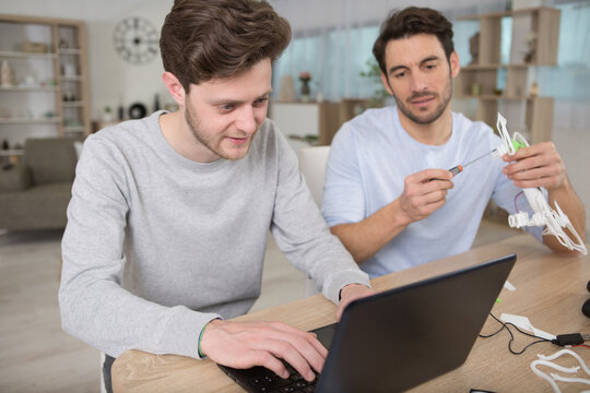 engineer and technician working together on drone in office