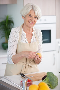 senior woman is peeling an apple