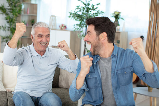 happy young son and old father celebrating success