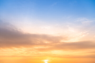 Obraz premium Sky sunset,Beautiful sunrise sky with vibrant gradient orange and gold colors and soft blue, Clear atmosphere with wispy clouds. Peaceful, perfect for background and copy space, High resolution images