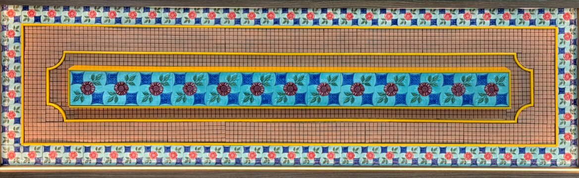 Close up of decorative colonial heritage tiles with ornamental and ornate pattern in mix of blue, teal, and red colors. With brown wood rattan material finish. Seamless background texture.