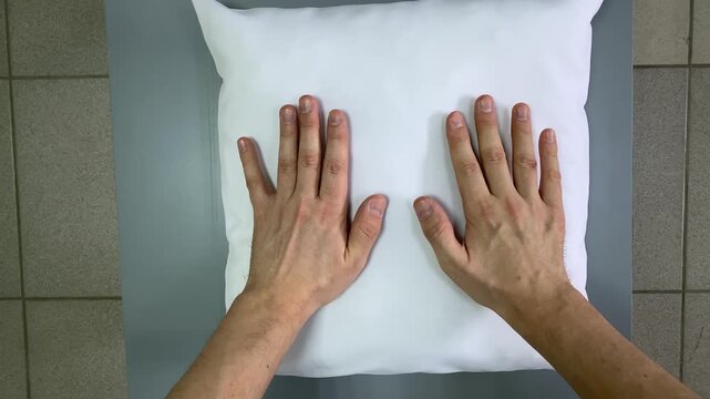 White pillow. Male hands. Slow motion video. . High quality 4k footage