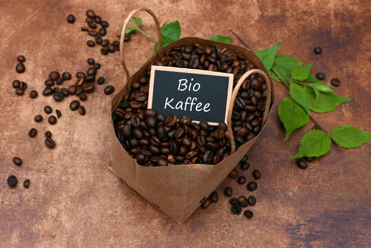 Bio Kaffee Bohnen in nachhaltiger Papiert&uuml;te auf rustikalem Hintergrund. Fair Trade Konzept.