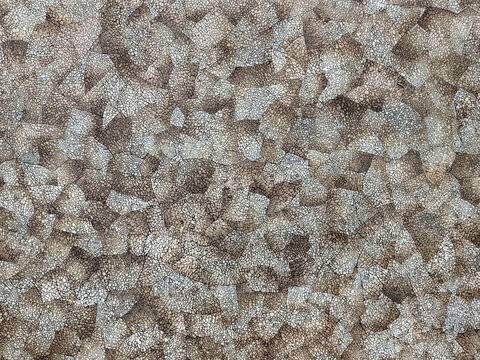 Graphic background of eggshell grainy mosaic pattern in brown and white color finish. Used as a base for decorative trays, wall panel, or surface texture. Seamless background texture.