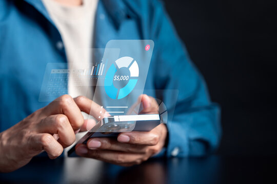 Investment and financial management concept on smartphone. Man using fintech app with data hologram for banking and wealth.